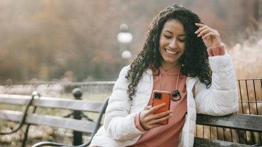 woman on bench holding phone overcoming feeling stuck in life
