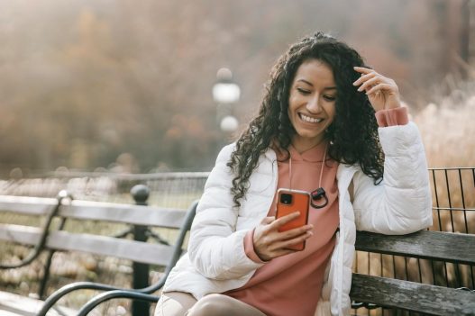 woman on bench holding phone overcoming feeling stuck in life